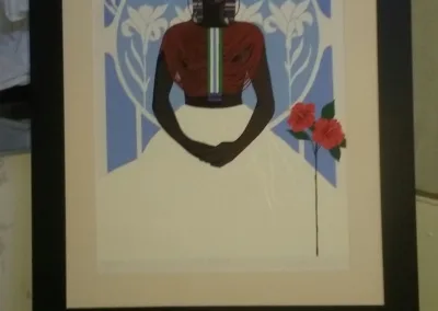 A framed print of a black woman with flowers.