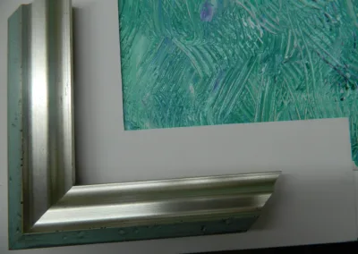 A silver frame with a green painting on it.